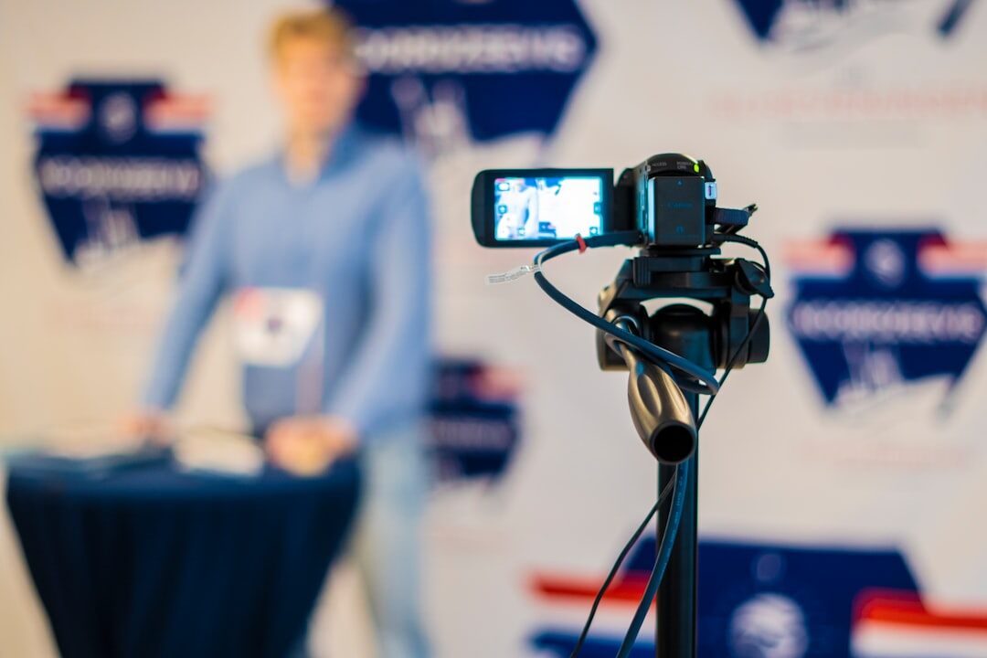 Journalist holding a microphone reporting in front of a camera